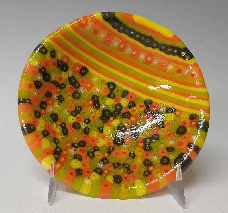 inside of glass bowl patterned with dots and stripes in yellows, oranges, greens, and black