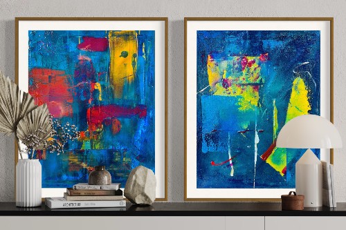 vignette of two abstract paintings on wall in a room, each of large impressionistic rectangles in bright hues of reds, blues, yellows, and green