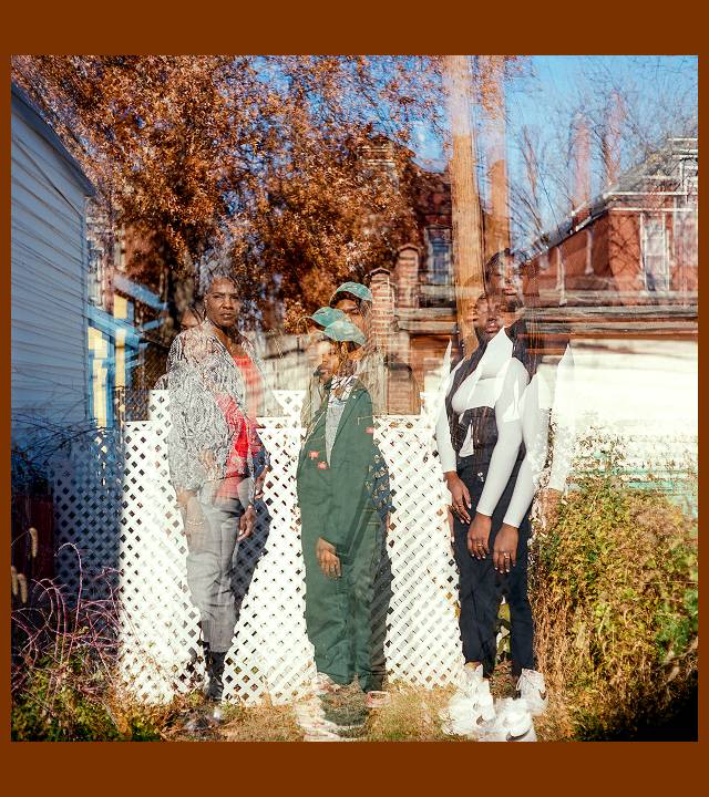 Photo of three women standing next to a fence in a small backyard, with multiple exposures so that each of them as well as their surroundings is doubled or tripled with each image slightly overlapping the others