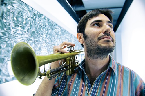 Close-up of man holding trumpet while gazing pensively upward