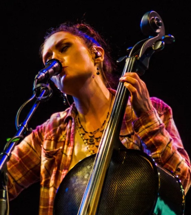 Dramatically lit close-up photo of woman playing a string bass