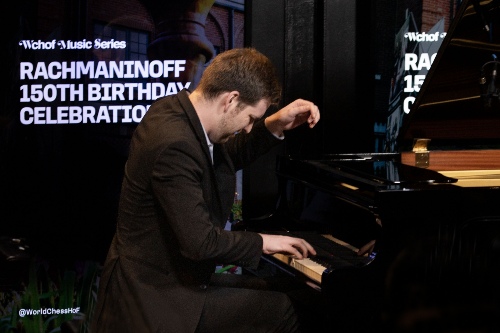 Man viewed in profile playing a grand piano