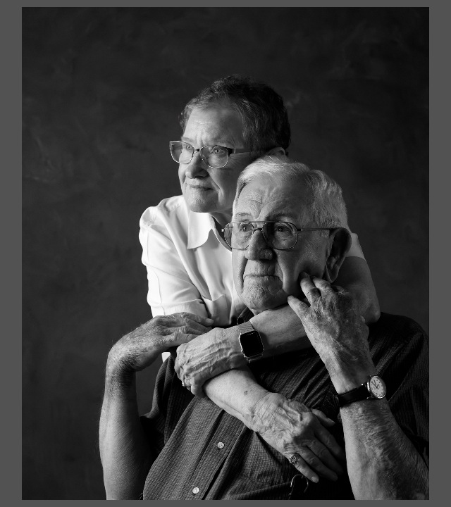 Black and white photo of elderly man and woman embracing